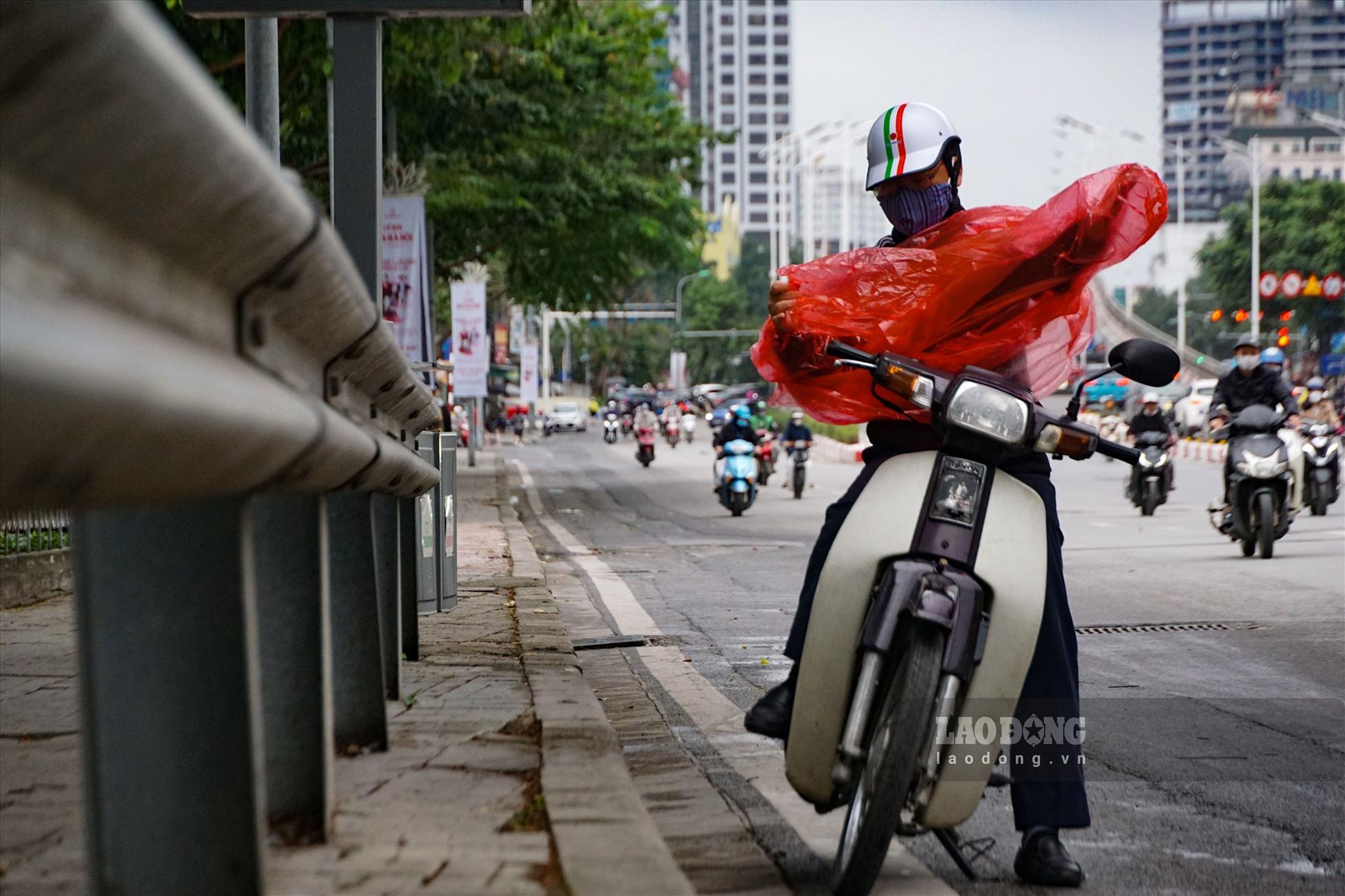 Những chiếc áo mưa không chỉ giúp người đi đường tránh mưa mà còn giảm cái lạnh do nhiệt độ xuống thấp.