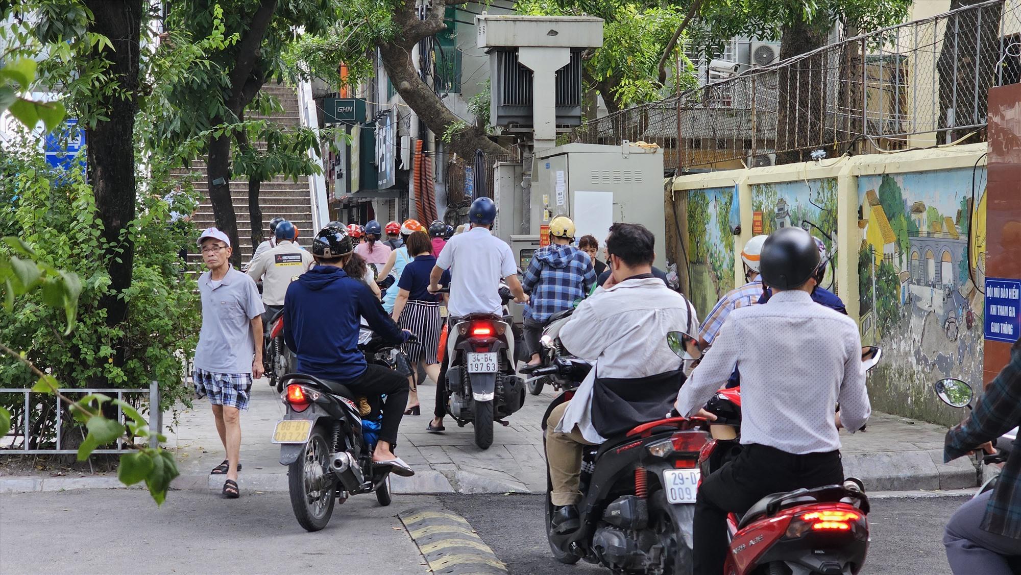 Các phương tiện lao lên vỉa hè, chiếm lối đi của người đi bộ.