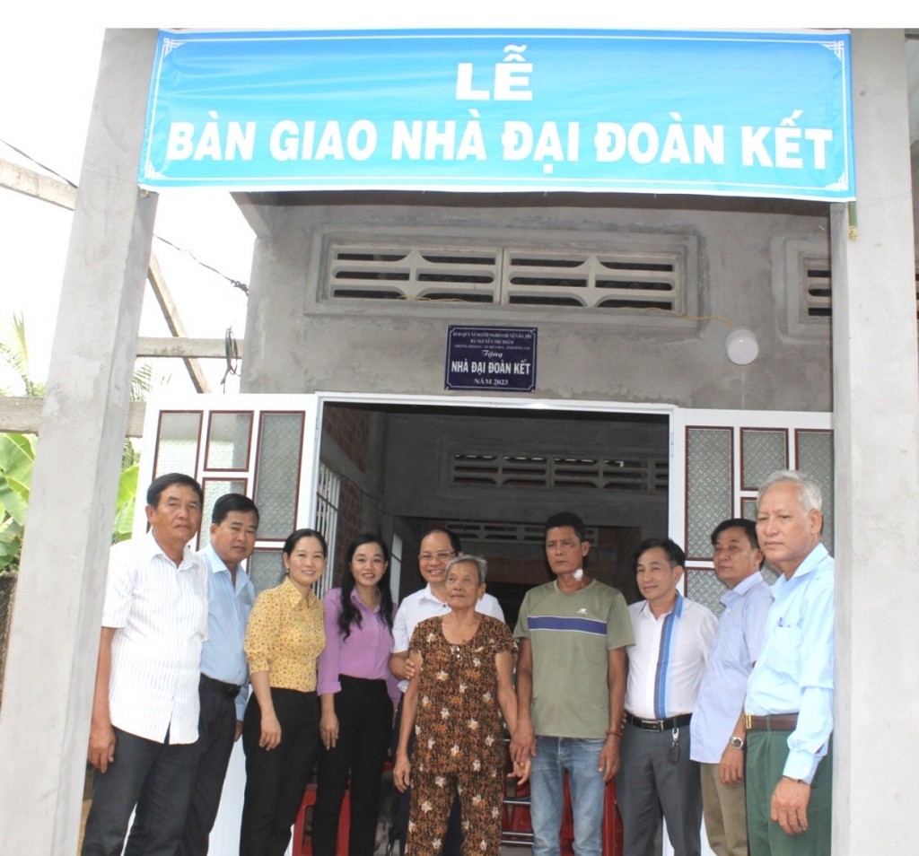 Các đại biểu tham dự lễ bàn giao nhà đại đoàn kết chung vui với hộ bà Trần Thị Đường