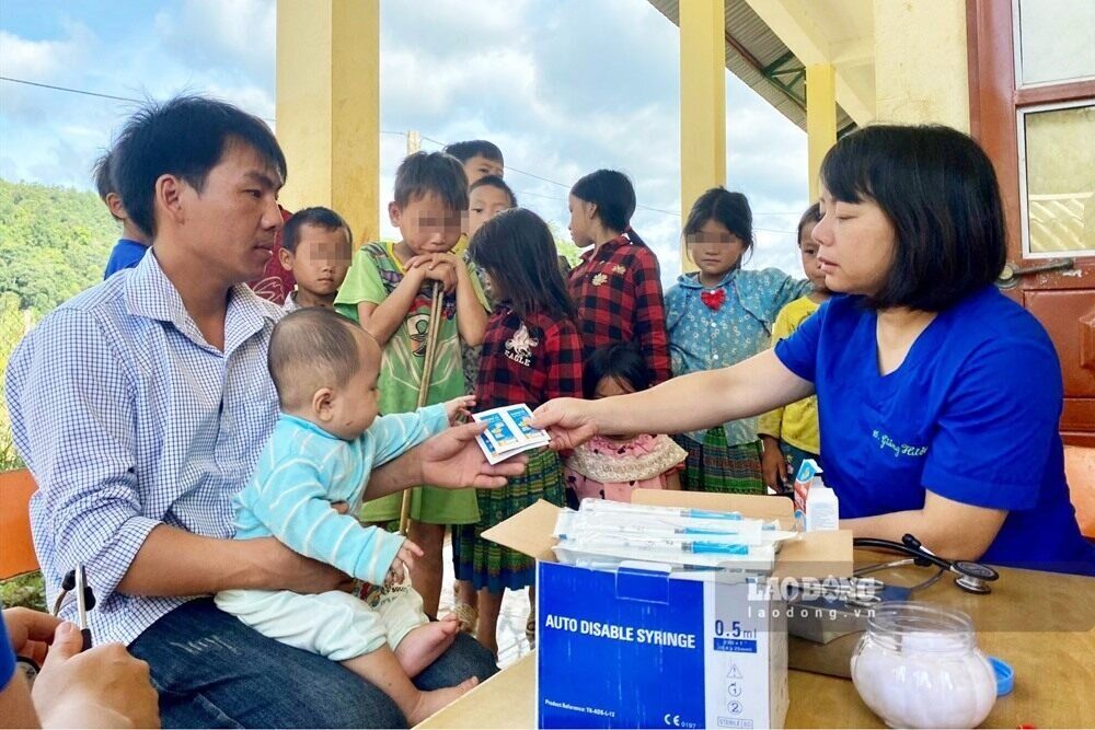 Hàng tháng, các y, bác sĩ ở trạm y tế vùng cao phải ngược núi hàng chục cây số, cõng vắc xin đến tận nơi tiêm chủng cho bà con. Ảnh: Khánh Linh