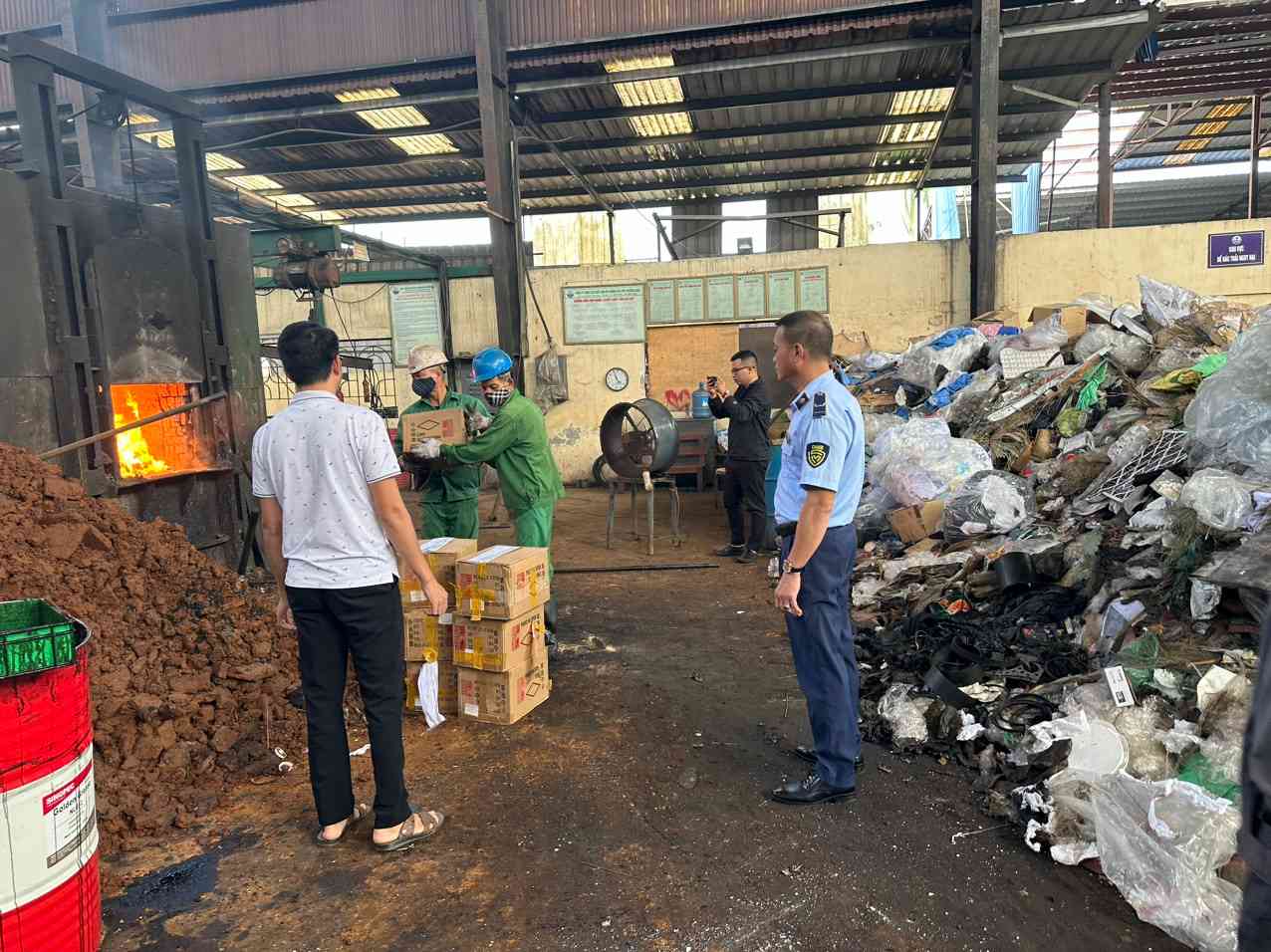 Lực lượng chức năng giám sát tiêu hủy hàng hóa không rõ nguồn gốc xuất xứ. Ảnh: Cục QLTT tỉnh Hải Dương