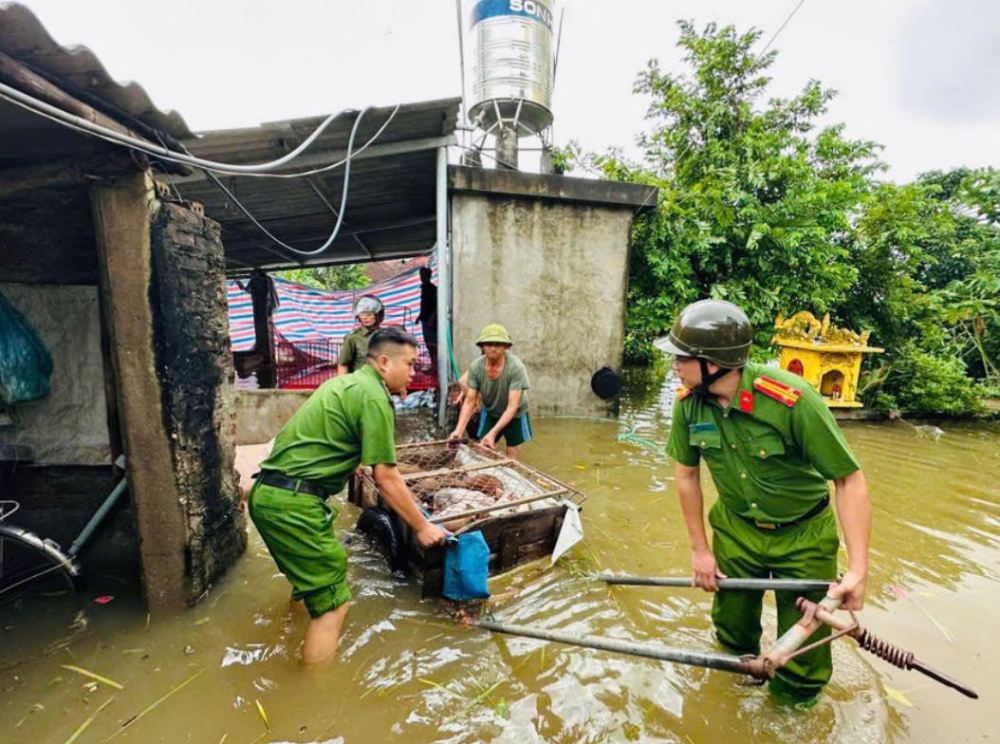 Công an huyện Mỹ Đức giúp dân sơ tán. Ảnh: Chu Dũng