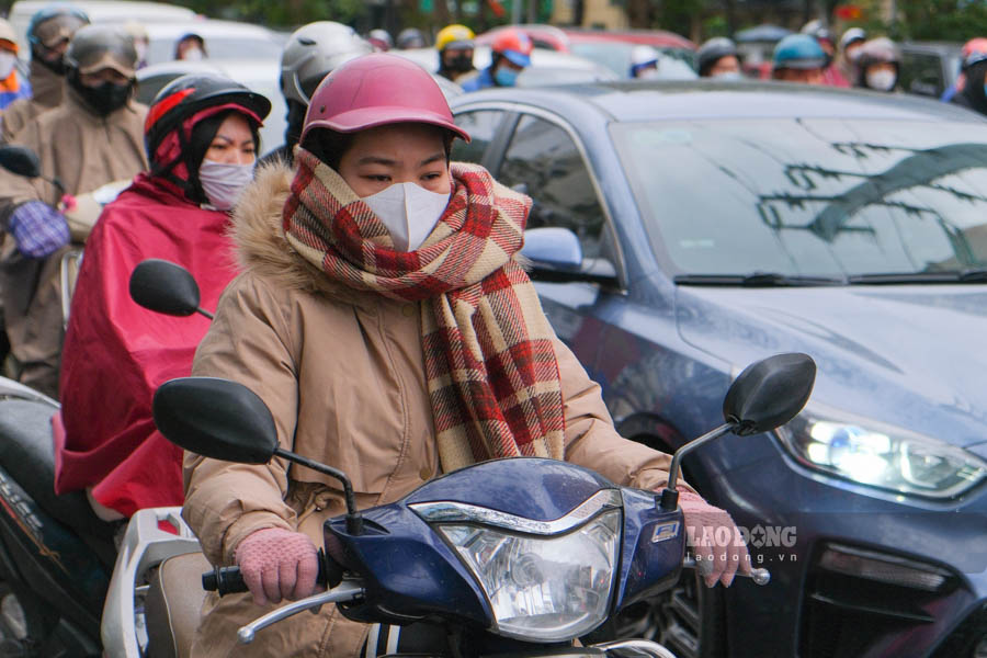 Trời chuyển rét đậm kèm mưa phùn khiến người Hà Nội co ro trong áo ấm và áo mưa khi ra đường.