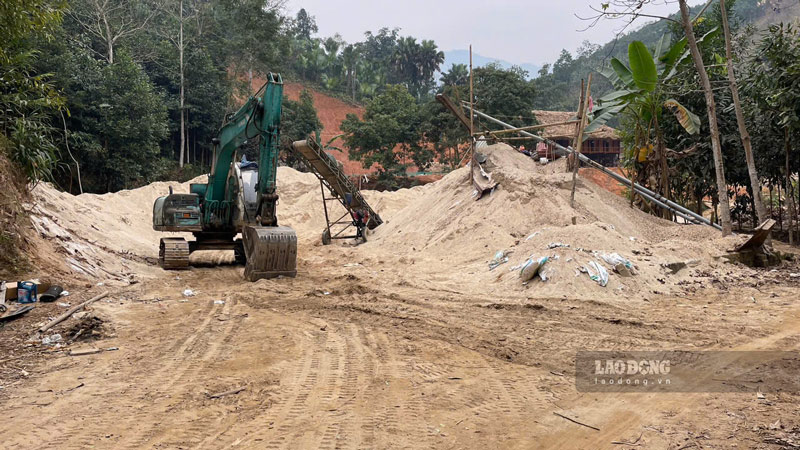 Máy xúc cùng hàng chục khối cát được tập kết bên cạnh lòng suối Nặm Luông, xã Nghĩa Đô (Bảo Yên, Lào Cai) để chờ vận chuyển đi tiêu thụ.