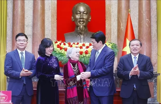 Chủ tịch nước Lương Cường thăm hỏi y tá Nguyễn Thị Kim Lai - nhân vật “O du kích nhỏ” trong tác phẩm ảnh đen trắng của nhà báo Phan Thoan. Ảnh: Lâm Khánh/TTXVN