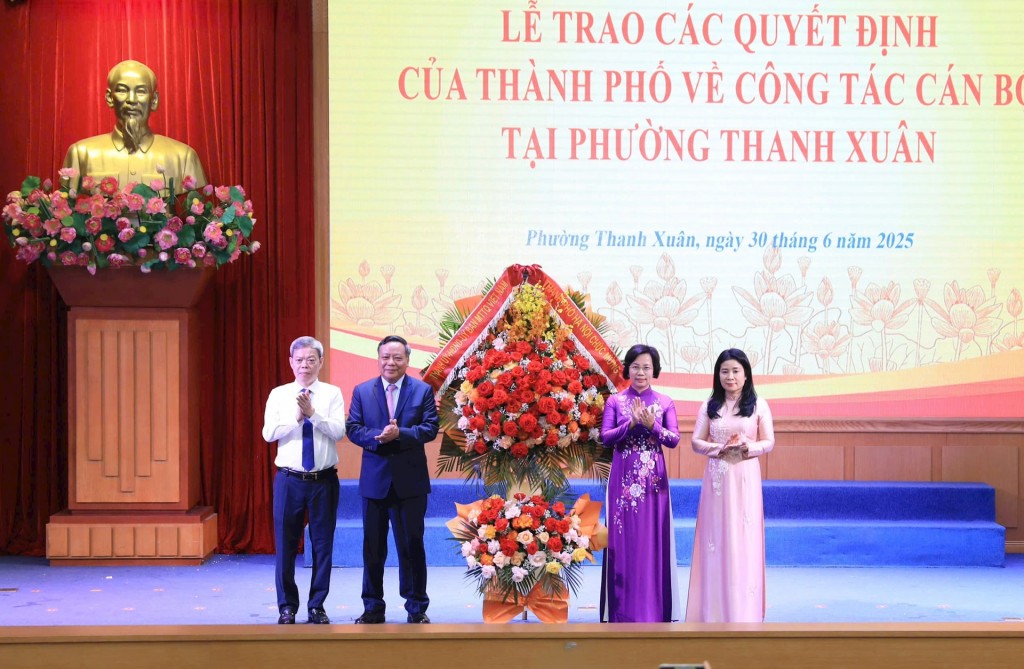 Phó Bí thư Thường trực Thành ủy Hà Nội Nguyễn Văn Phong tặng hoa chúc mừng các cán bộ chủ chốt của Đảng bộ phường Thanh Xuân. Ảnh: Quang Thái