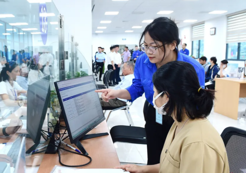 Thanh niên tình nguyện hỗ trợ tại Trung tâm phục vụ hành chính công phường Cầu Giấy sáng 7/7. Ảnh: Xuân Tùng