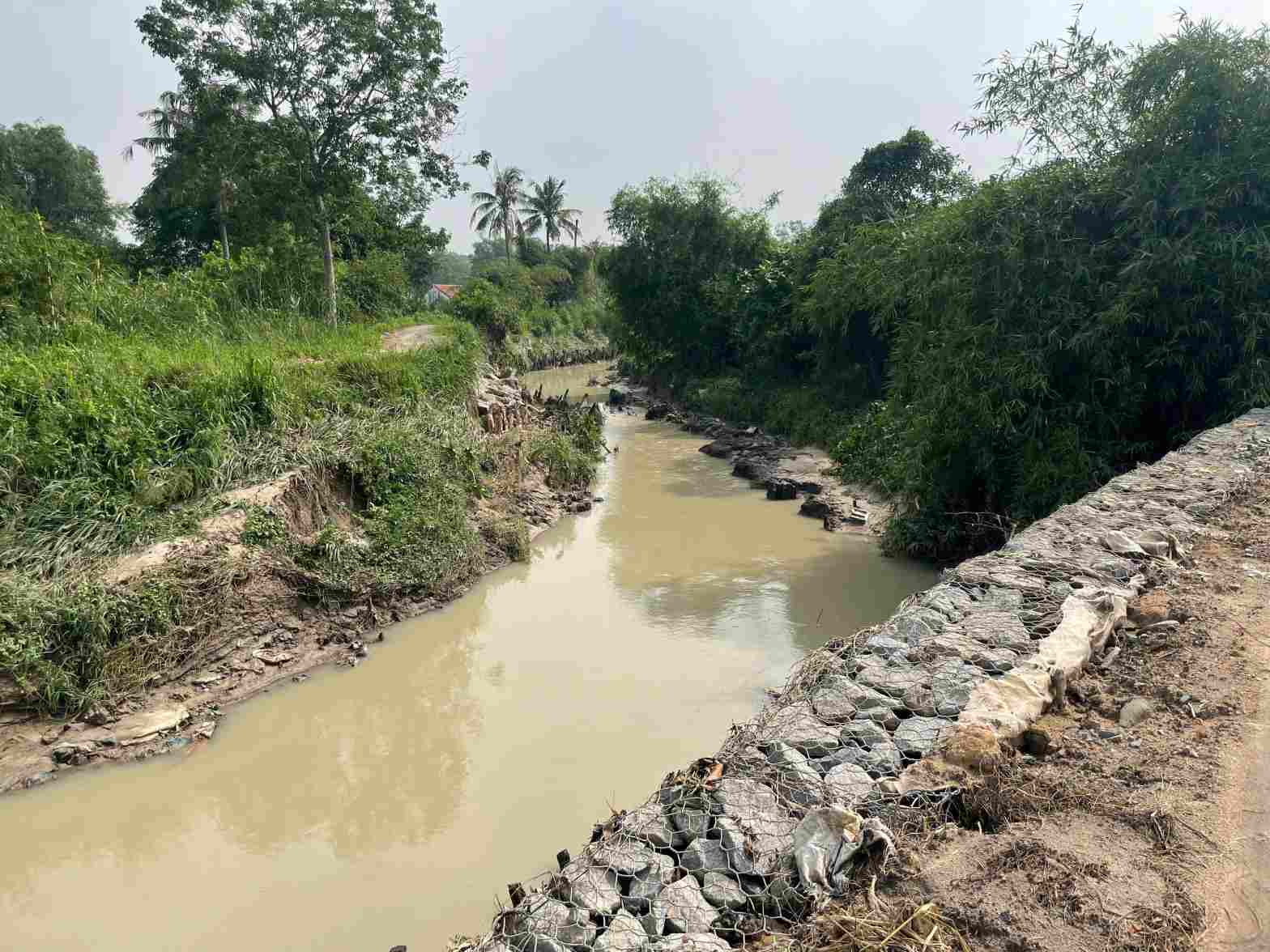 Đoạn suối được kè bờ đá, tuy nhiên mưa lớn nước chảy siết đã cuốn trôi cả bờ kè. Ảnh: Đình Trọng