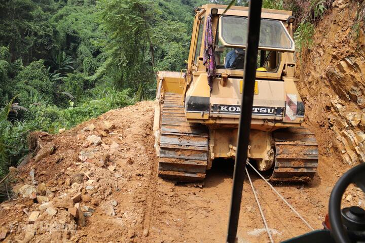 Chiếc xe công nông đưa chúng tôi lên vị trí cột được kéo bằng một chiếc xe ủi bánh xích khác. Ảnh: Thanh Tuấn