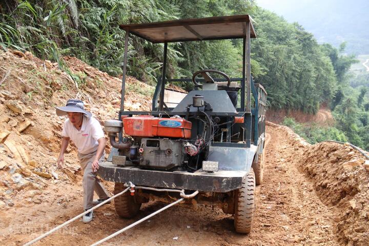 Địa hình phức tạp với dốc cao, đường trơn trượt khiến việc tiếp cận vị trí cột trở nên gian nan. Chiếc xe công nông chở chúng tôi buộc phải dừng lại khi mới đi được 1/3 chặng đường. Ảnh: Thanh Tuấn