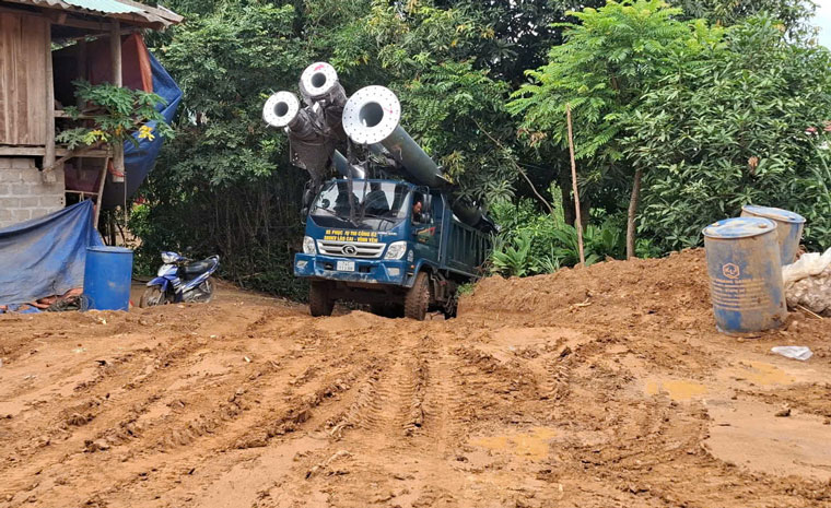 Những chiếc xe tải chở vật liệu lên dốc phải đi kèm với một máy xúc bánh xích để vượt dốc.