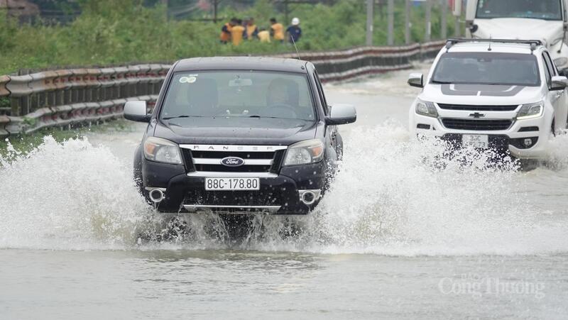 Một chiếc xe bán tải vượt ngập, nước bắn tung tóe