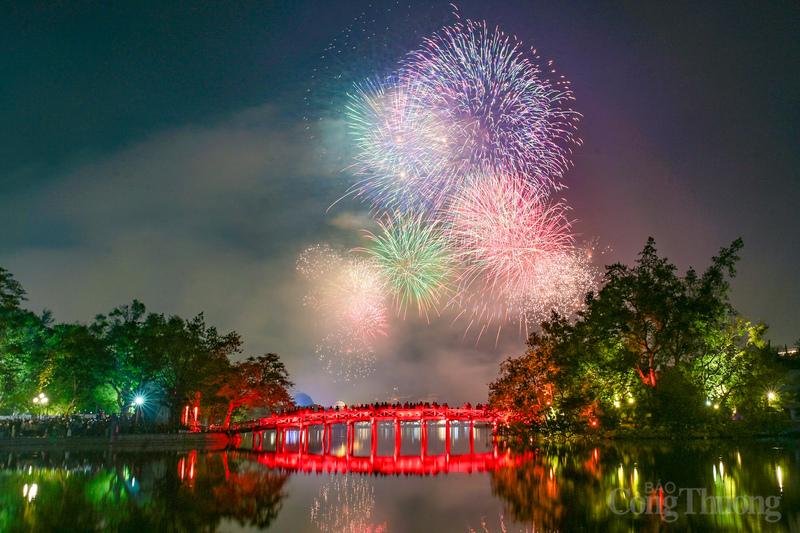 Những chùm pháo hoa rực rỡ phản chiếu xuống mặt nước, thu hút đông đảo người dân và du khách dạo quanh phố đi bộ.