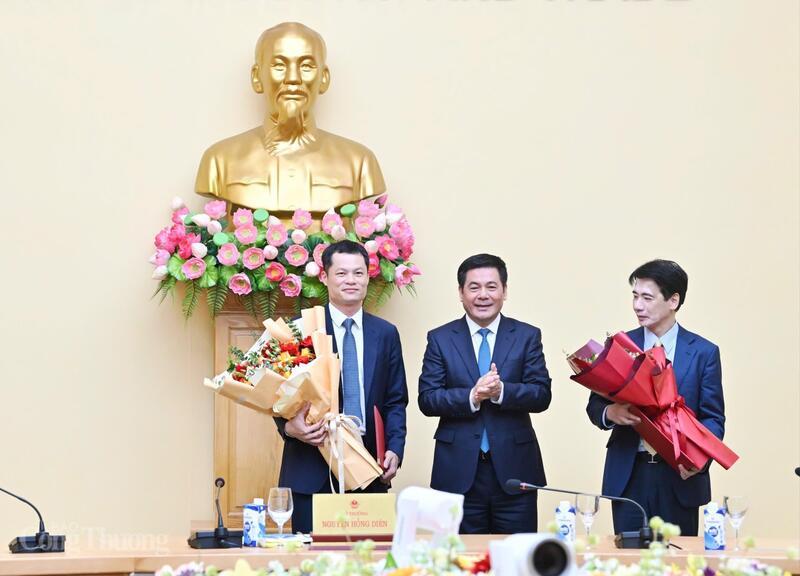 Bộ trưởng tặng hoa chúc mừng ông Tạ Hoàng Linh và ông Đỗ Quốc Hưng.