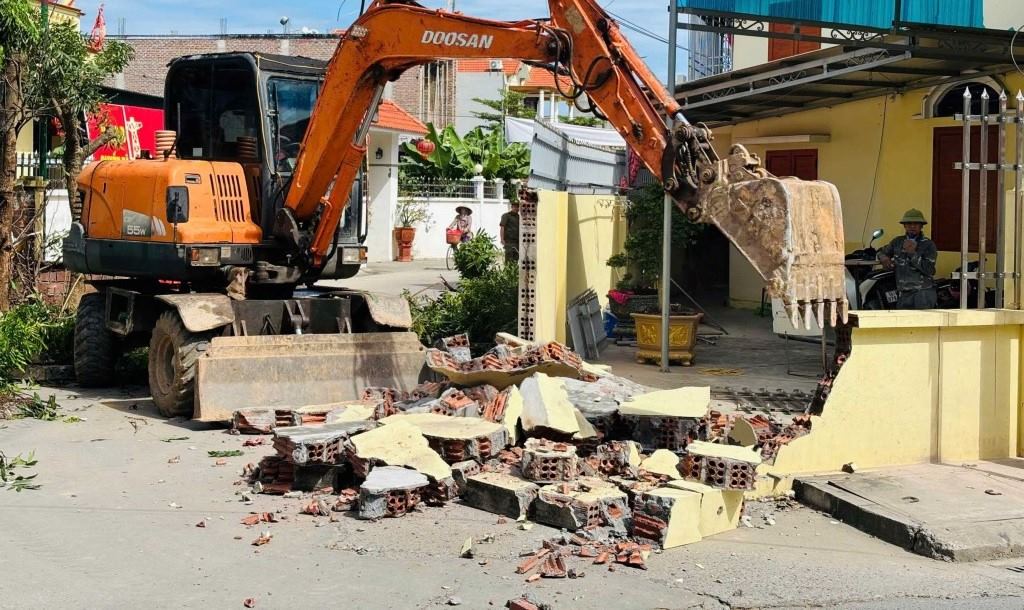 Một hộ dân ở phường Liên Hòa, tỉnh Quảng Ninh tự nguyện tháo dỡ cổng, dịch chuyển tường rào, hiến đất để thi công công trình. Ảnh Mai Hương