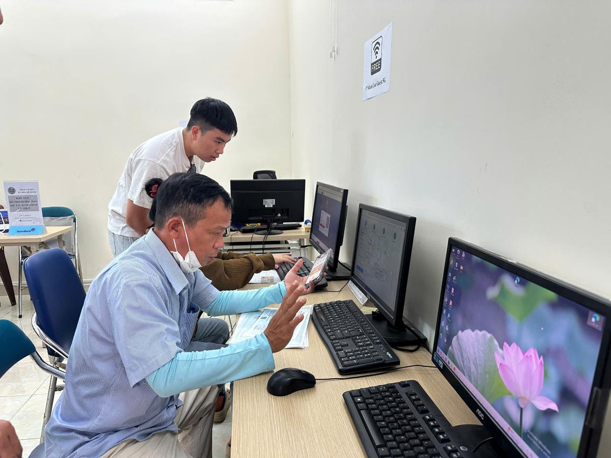 Cán bộ phụ trách phường Nhiêu Lộc hướng dẫn, hỗ trợ người dân nộp hồ sơ trực tuyến. Ảnh: Minh Tâm